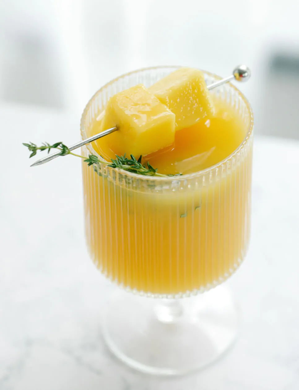 a refreshing yellow drink in a stemmed glass